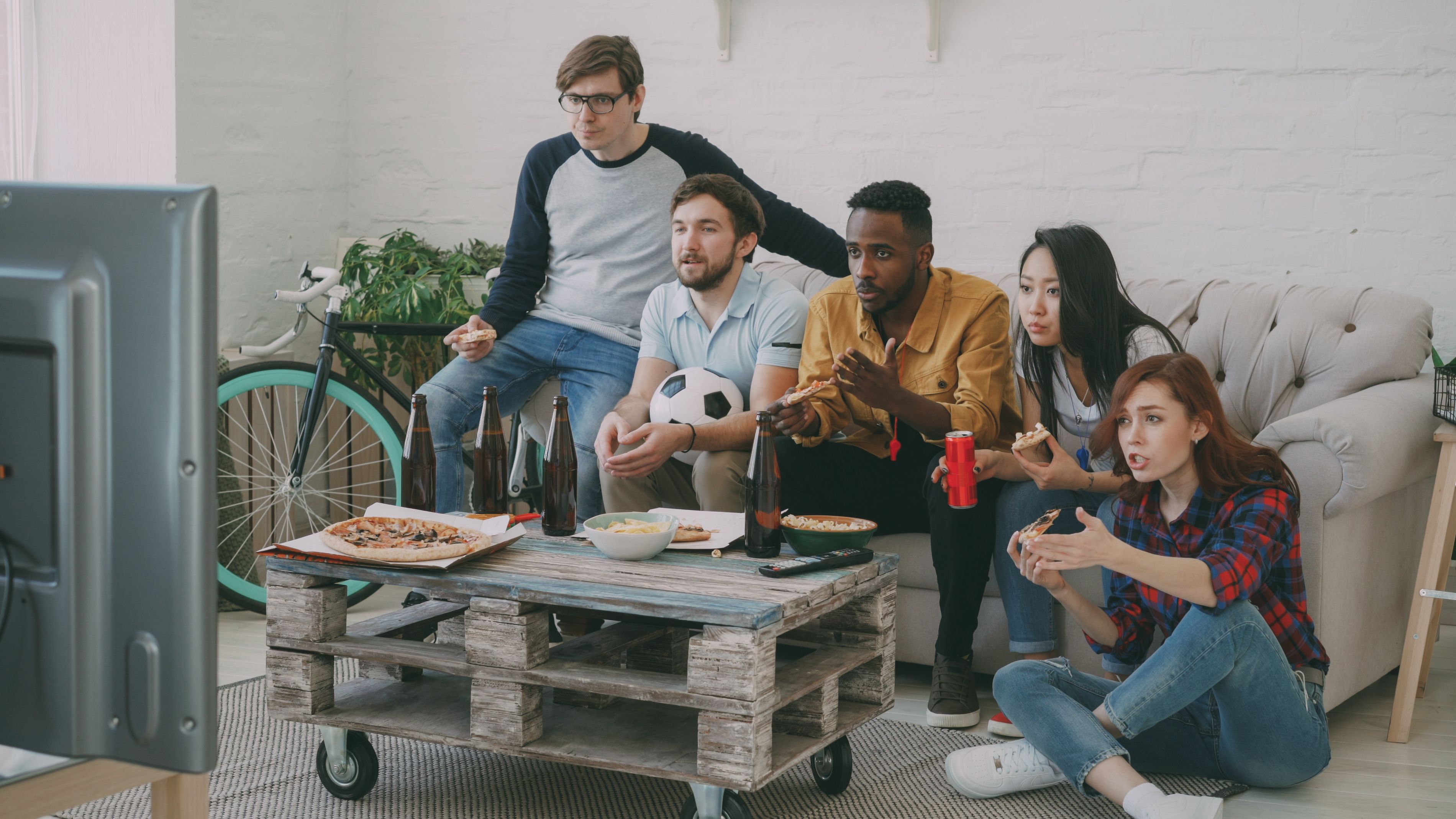A group of friends watching sports together in a living room